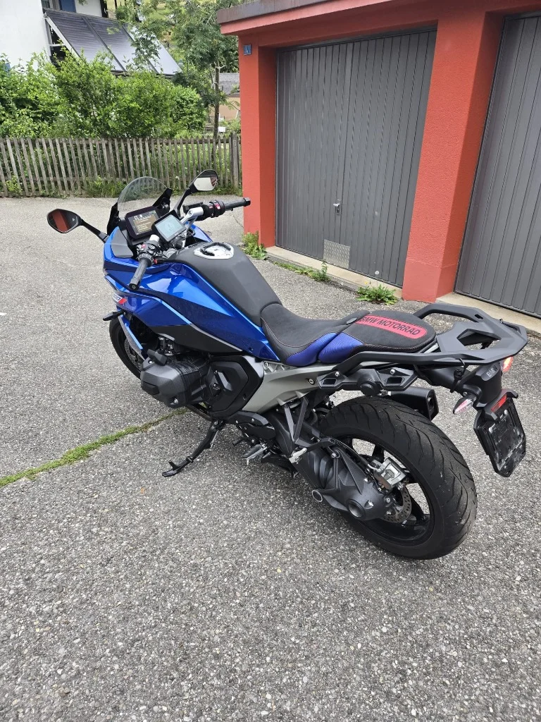 Wyprofilowana, customowa kanapa motocyklowa BMW Motorrad z haftem i niebiesko-czerwonymi akcentami na niebieskim motocyklu BMW R1300Rs